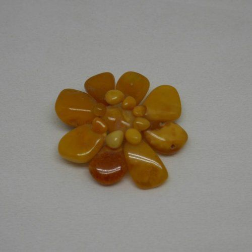 alt="Broche de ámbar en forma de flor en tonos amarillos"