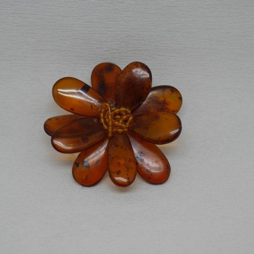 alt=\"Broche de ámbar, cuero y plata en forma de flor\"