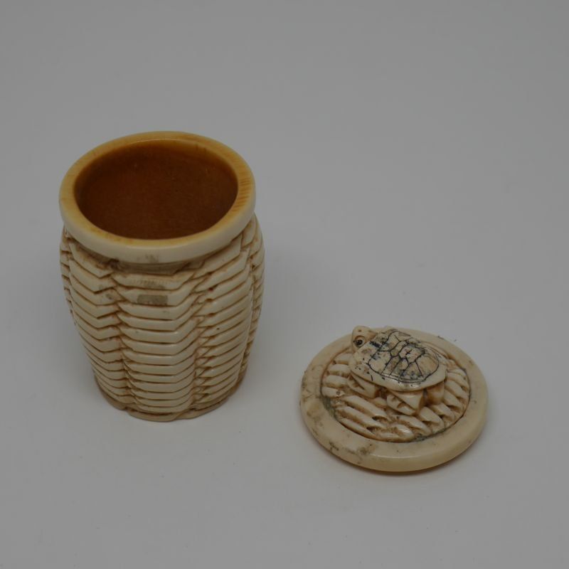 Caja de hueso fabricada a mano en forma de tibor con relieve de tortura