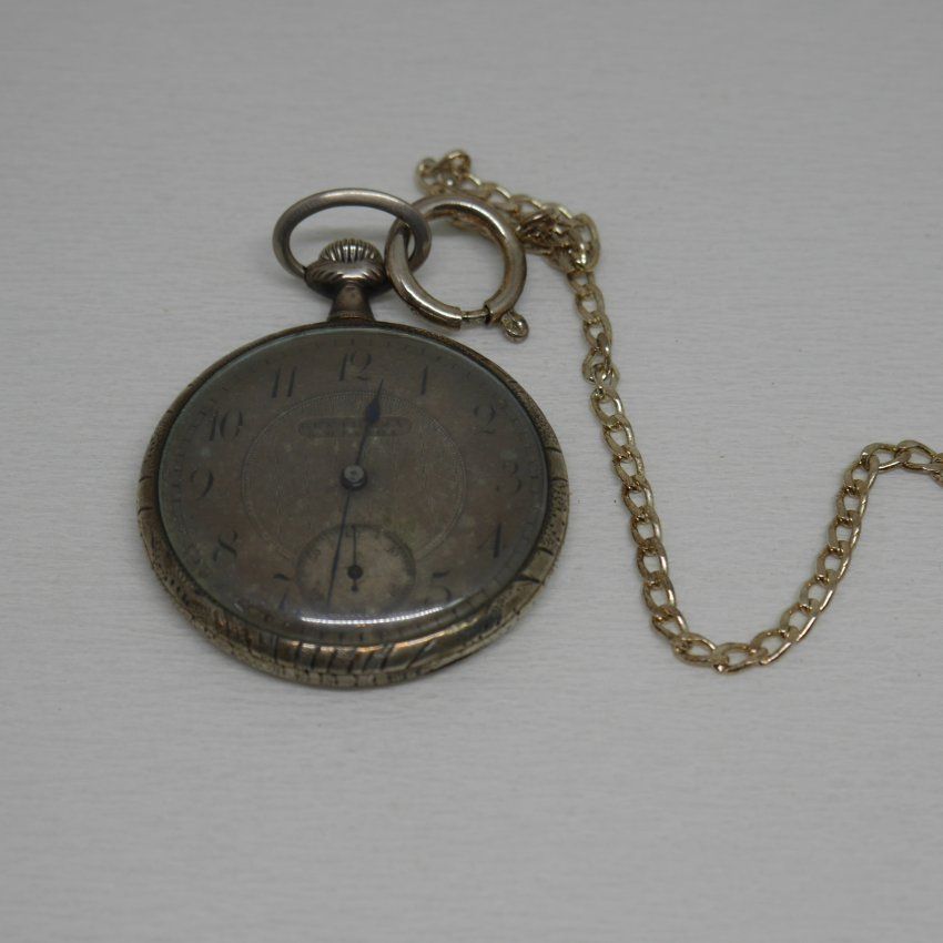 alt=\"Reloj antigüo de bolsillo caballero con cadena y caja de plata de ley marca Gentileza en estado de marcha\"