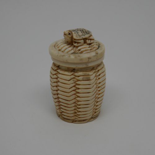 Caja de hueso fabricada a mano en forma de tibor con relieve de tortura