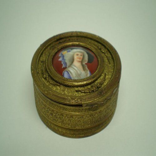 alt=\"Caja antigua de latón ovalada con relieves\"