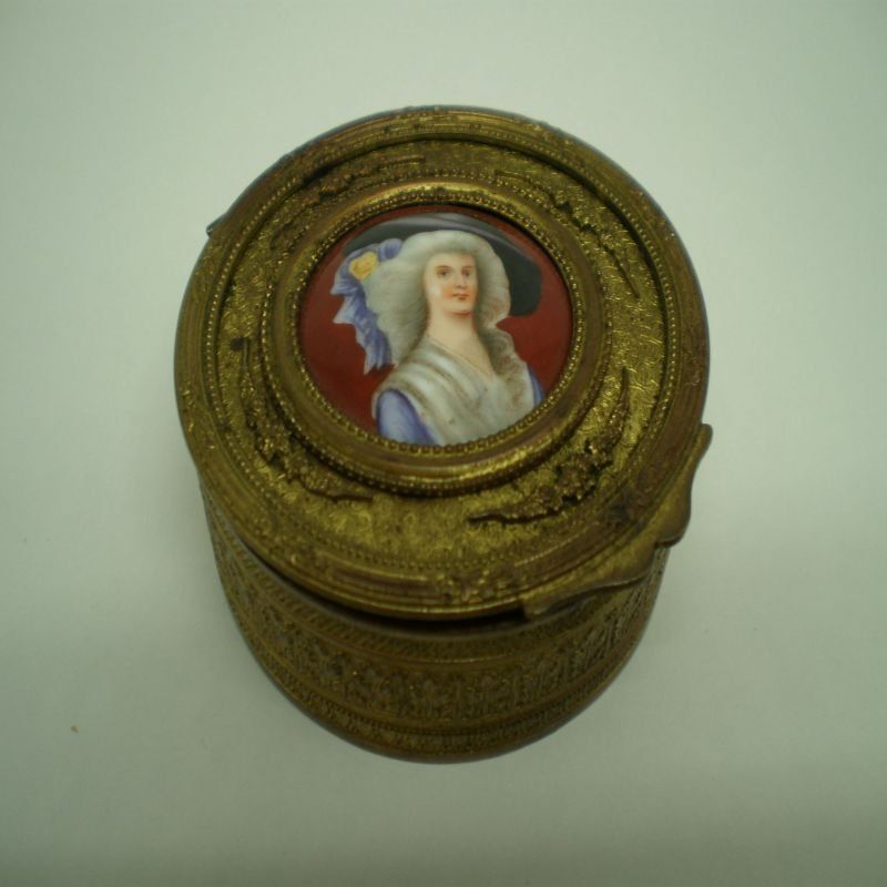 alt=\"Caja antigua de latón ovalada con relieves\"