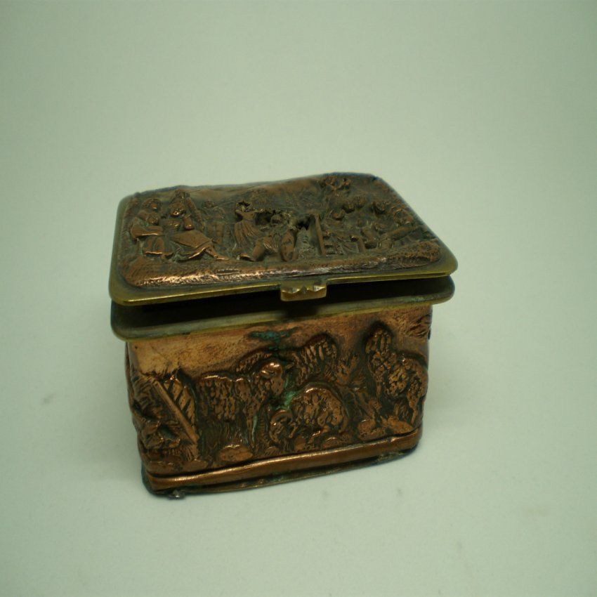 alt=\"Caja antigua de latón rectangular con relieves\"