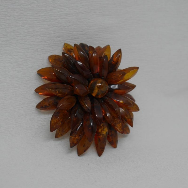 alt=\"Broche de ámbar en forma de flor color miel\"