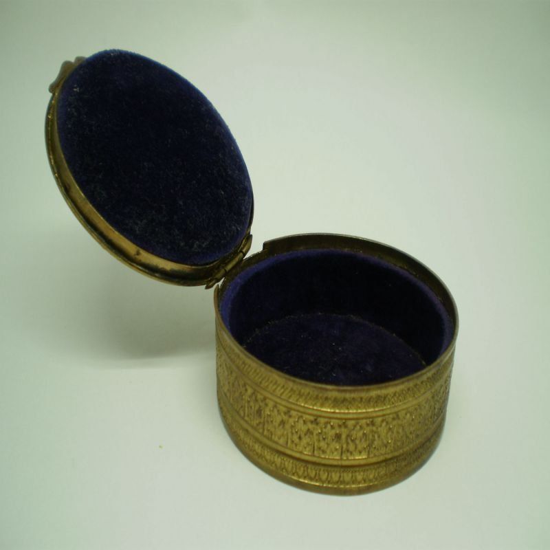 alt=\"Caja antigua de latón ovalada con relieves\"