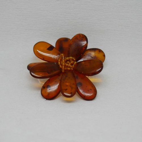 alt=\"Broche de ámbar, cuero y plata en forma de flor\"