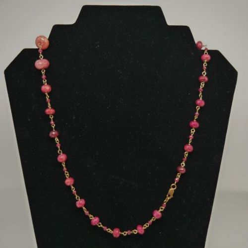 alt=\"Collar de oro de ley 18 K con rubies facetados en disminución\"