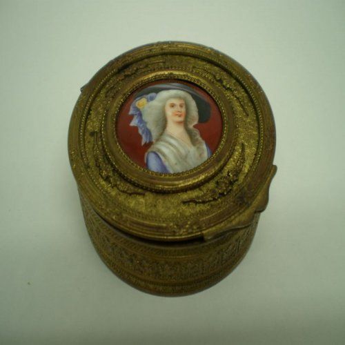 alt=\"Caja antigua de latón ovalada con relieves\"