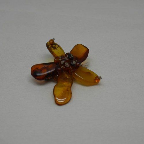 alt=\"Broche de ámbar y plata en forma de flor\"