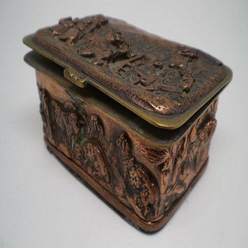 alt=\"Caja antigua de latón rectangular con relieves\"